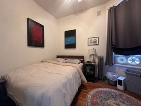 Chicago apartment for rent - A bedroom with a large bed and a window with a view of the sky.