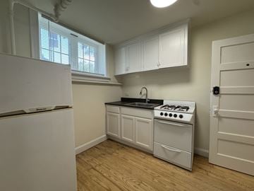 Chicago apartment for rent - A kitchen with a white stove and cabinets.