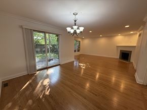 Winnetka townhouse for rent - A large empty room with wooden floors and a chandelier.