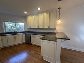 Winnetka townhouse for rent - A kitchen with white cabinets and a granite countertop.