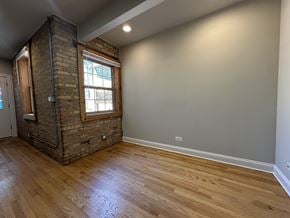 Chicago apartment for rent - A room with a brick chimney and wooden flooring.