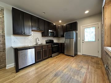 Chicago apartment for rent - A kitchen with wooden floors and stainless steel appliances.