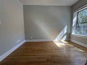 Chicago apartment for rent - A room with wooden flooring and a window letting in sunlight.