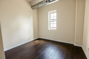 Chicago apartment for rent - A room with wooden floors and a window.