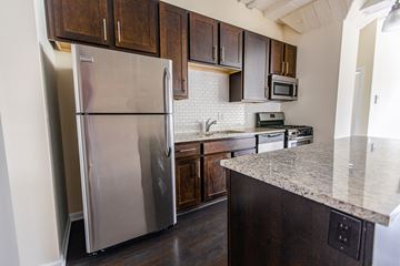 Chicago apartment for rent - A kitchen with a stainless steel refrigerator and dark wood cabinets.