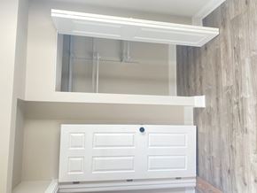 Chicago apartment for rent - A white cabinet with a black knob is in a room with a grey wall.