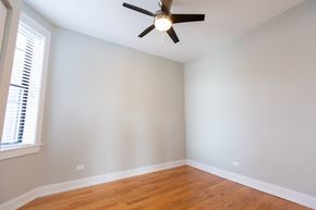 Chicago apartment for rent - A room with a ceiling fan and wooden floors.