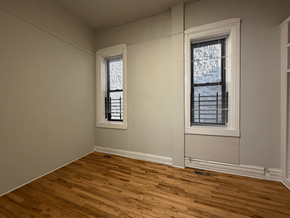 Chicago apartment for rent - A room with two windows and wooden flooring.