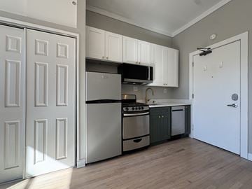 Chicago apartment for rent - A kitchen with white cabinets and a black stove top oven.