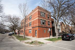 Chicago apartment for rent - A red brick building with a blue sign on the front.