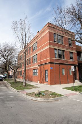 Chicago apartment for rent - A red brick building with a tree in front of it.