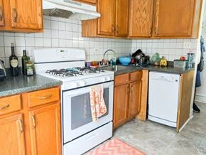 Chicago apartment for rent - a kitchen with white appliances and wooden cabinets