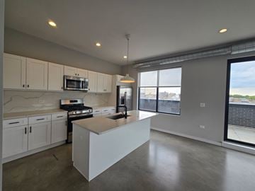 Chicago apartment for rent - A kitchen with white cabinets and a large island.