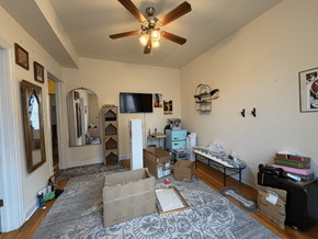 Chicago apartment for rent - A room with a ceiling fan and boxes on the floor.