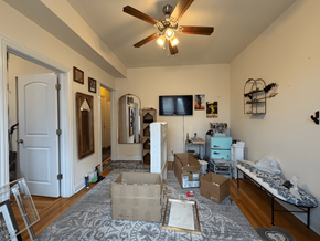 Chicago apartment for rent - A room with a ceiling fan and boxes on the floor.