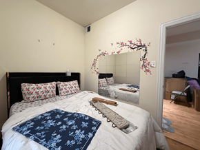 Chicago apartment for rent - A bedroom with a large bed and a mirror with a cherry blossom design on it.