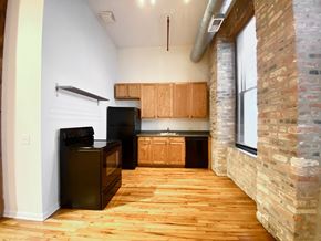 Chicago apartment for rent - A kitchen with wooden floors and a brick column.