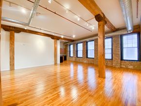 Chicago apartment for rent - A large room with wooden floors and exposed beams.