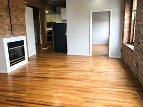 Chicago apartment for rent - A room with wooden floors and a fireplace.