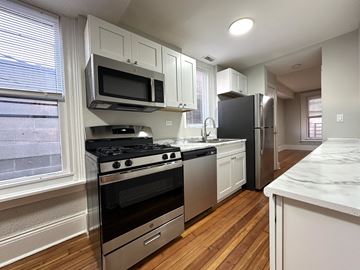 Chicago apartment for rent - A kitchen with a stove top oven and microwave above it.