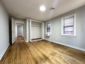Chicago apartment for rent - A room with wooden floors and white walls.