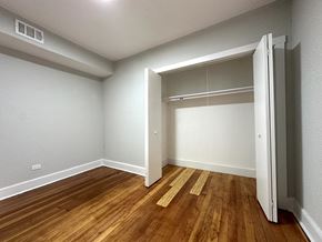 Chicago apartment for rent - A room with a wooden floor and a white door.