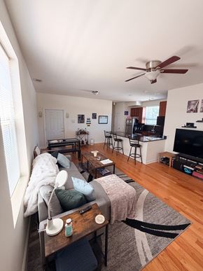 Chicago apartment for rent - A living room with a couch, a coffee table, and a ceiling fan.