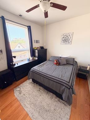 Chicago apartment for rent - A bedroom with a bed, dresser, and window.