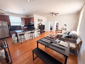 Chicago apartment for rent - A modern kitchen with a breakfast bar and a living room with a couch.