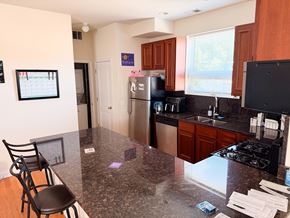 Chicago apartment for rent - A kitchen with a black granite countertop and a black chair.