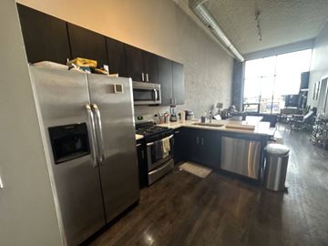 Chicago apartment for rent - A modern kitchen with a stainless steel refrigerator and black cabinets.