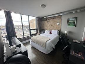 Chicago apartment for rent - A bedroom with a large bed and a view of the city.