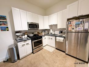 Chicago apartment for rent - A kitchen with white cabinets and a stainless steel refrigerator.