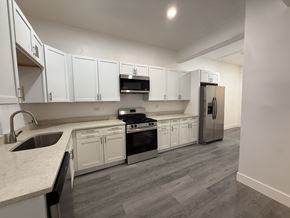 Chicago apartment for rent - A kitchen with white cabinets and a grey floor.