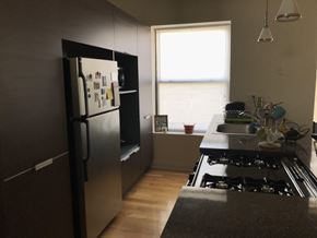 Chicago apartment for rent - A kitchen with a black fridge and stove top oven.