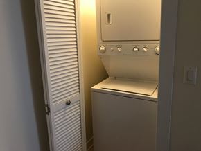 Chicago apartment for rent - A white oven with a door open is in a room with a white door to the left.