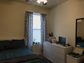 Chicago apartment for rent - A bedroom with a bed, dresser, and window with curtains.