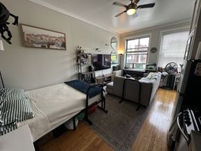 Chicago apartment for rent - A living room with a couch, a bed, and a television.