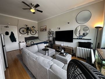 Chicago apartment for rent - A living room with a grey couch and a black chair.