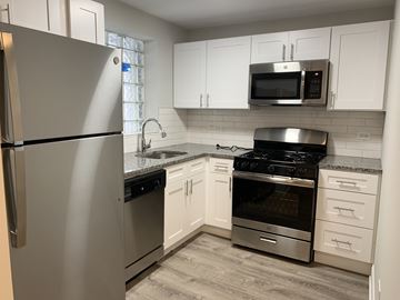 Chicago apartment for rent - A kitchen with a stainless steel refrigerator, microwave, oven, and stove.