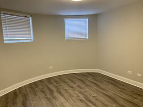 Chicago apartment for rent - A room with a wooden floor and two windows.