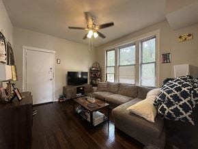 Chicago apartment for rent - A living room with a couch, a television, and a ceiling fan.