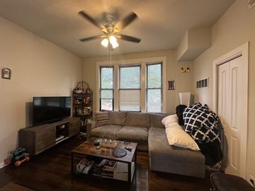 Chicago apartment for rent - A living room with a grey couch and a television.