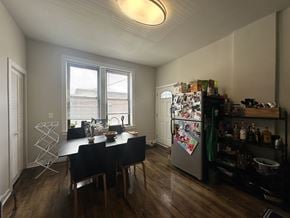 Chicago apartment for rent - A kitchen with a table and chairs and a refrigerator with magnets on it.