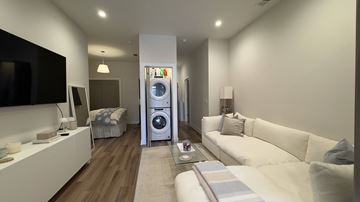 Chicago apartment for rent - A modern living room with a white sofa and a television on the wall.