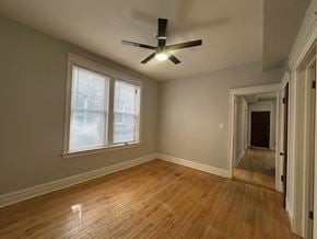Chicago apartment for rent - A room with a ceiling fan and wooden flooring.