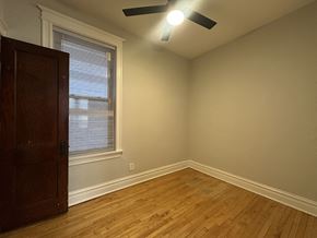 Chicago apartment for rent - A room with a ceiling fan and a wooden floor.