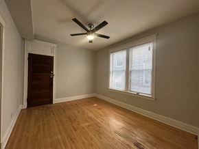 Chicago apartment for rent - A room with a ceiling fan and a window.