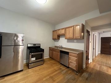 Chicago apartment for rent - A kitchen with wooden cabinets and a stainless steel refrigerator.