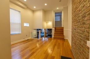 Chicago apartment for rent - A room with wooden floors and a brick wall.